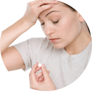 Image of girl holding head while taking painkillers.